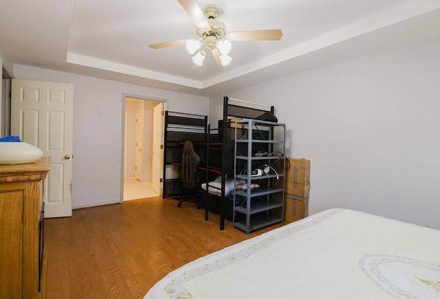 bedroom featuring ceiling fan, a tray ceiling, and hardwood / wood-style floors