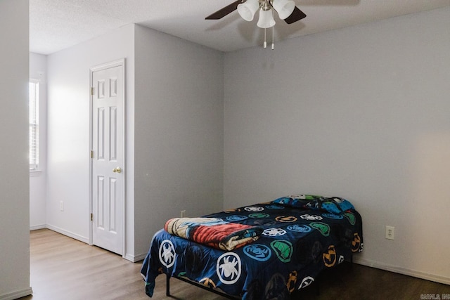 bedroom featuring ceiling fan, a textured ceiling, and wood-type flooring