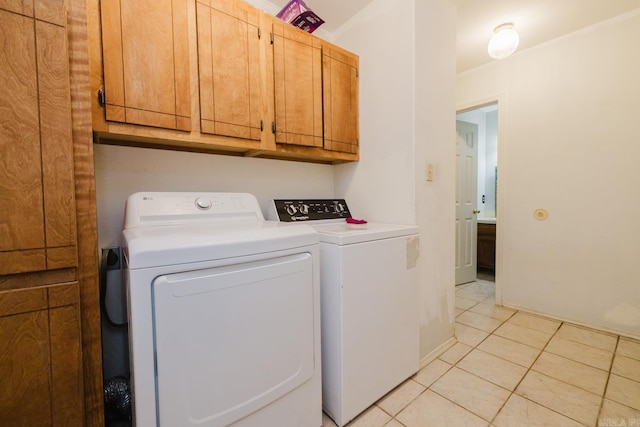 laundry area featuring cabinets, light tile patterned floors, and washer and clothes dryer