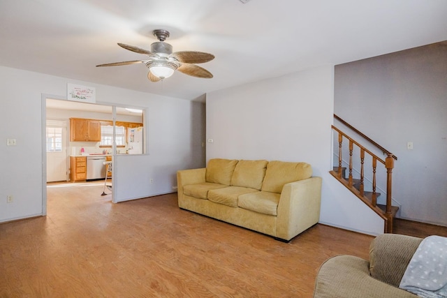 living room with ceiling fan and light hardwood / wood-style flooring