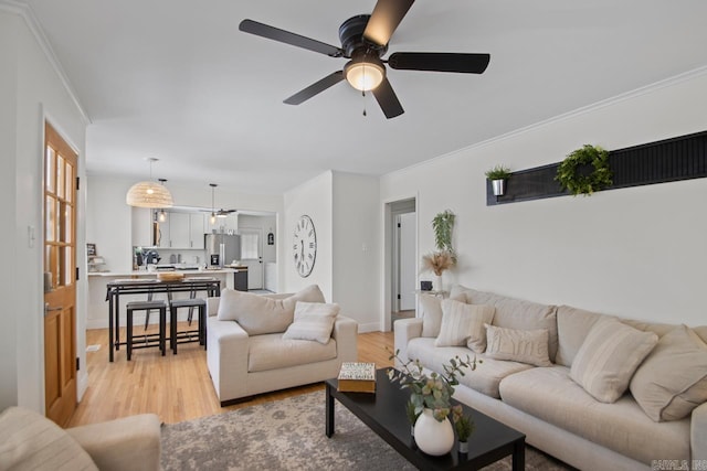 living room featuring ceiling fan, light hardwood / wood-style flooring, and crown molding