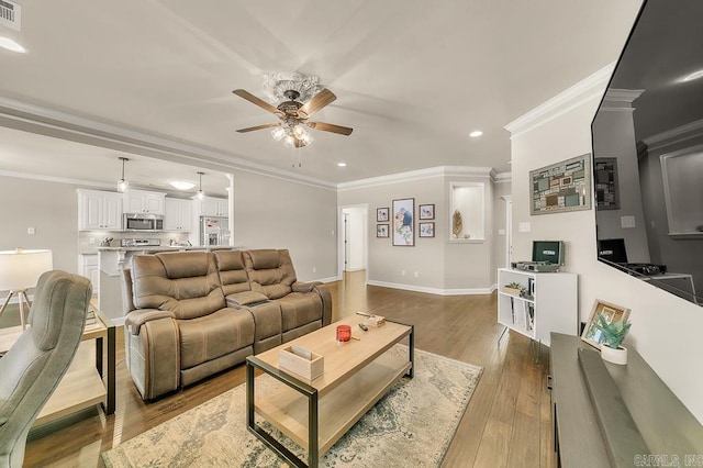 living room featuring ceiling fan, crown molding, and hardwood / wood-style floors