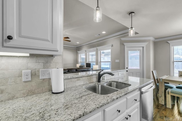 kitchen with sink, white cabinets, dishwasher, decorative backsplash, and crown molding