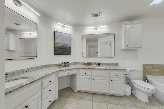 bathroom with tile patterned flooring, a tub, vanity, and toilet