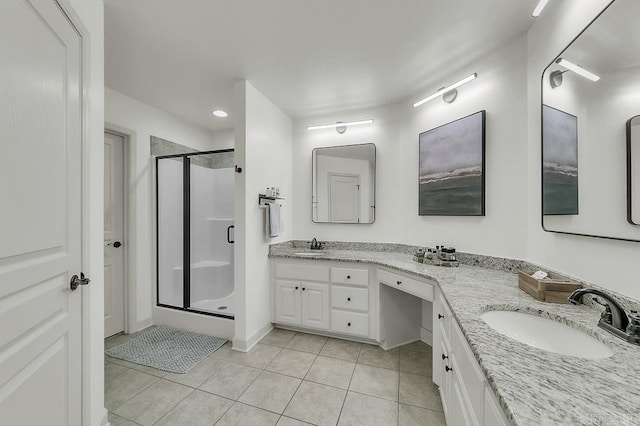 bathroom featuring tile patterned flooring, an enclosed shower, and vanity