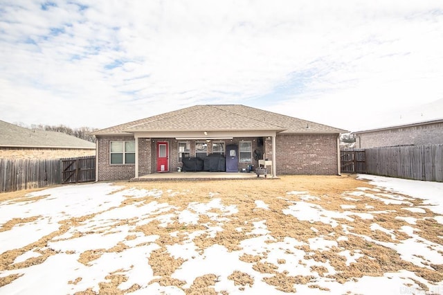 snow covered house featuring a patio