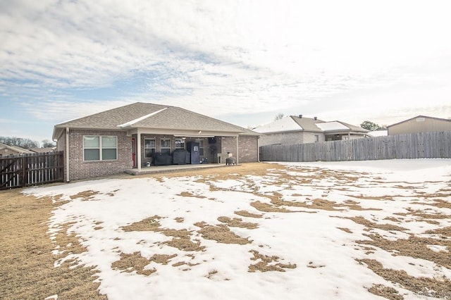 view of snow covered rear of property