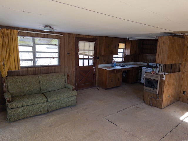 kitchen featuring light carpet, wooden walls, and heating unit