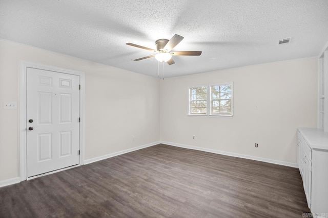 unfurnished room featuring a textured ceiling, ceiling fan, and dark wood-type flooring