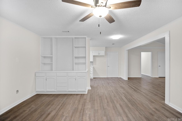 unfurnished living room featuring a textured ceiling, ceiling fan, and hardwood / wood-style floors