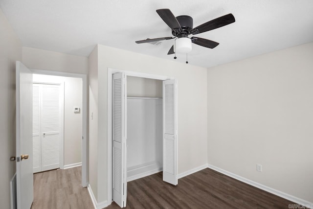 unfurnished bedroom featuring wood-type flooring, a closet, and ceiling fan