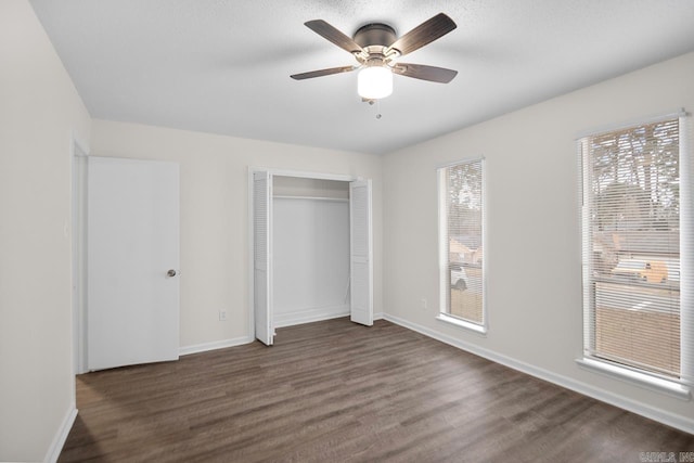 unfurnished bedroom featuring ceiling fan, dark hardwood / wood-style flooring, and a closet