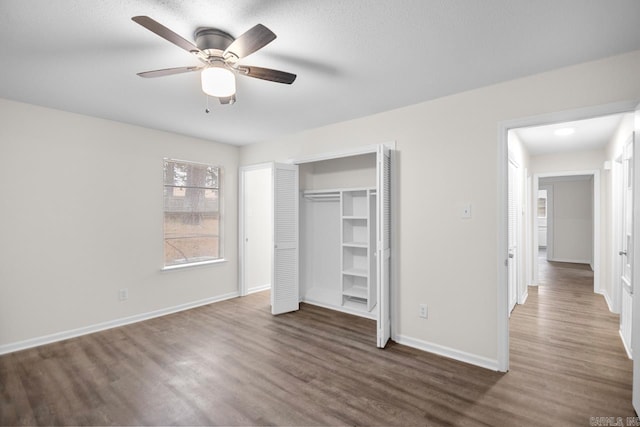 unfurnished bedroom featuring ceiling fan, dark hardwood / wood-style flooring, and a closet