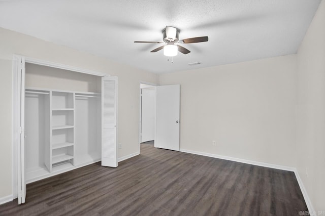 unfurnished bedroom featuring a closet, ceiling fan, a textured ceiling, and dark hardwood / wood-style floors