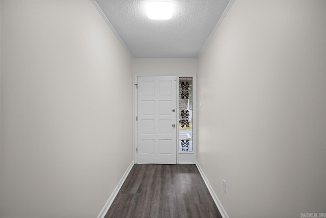 entryway featuring a textured ceiling, crown molding, and dark wood-type flooring