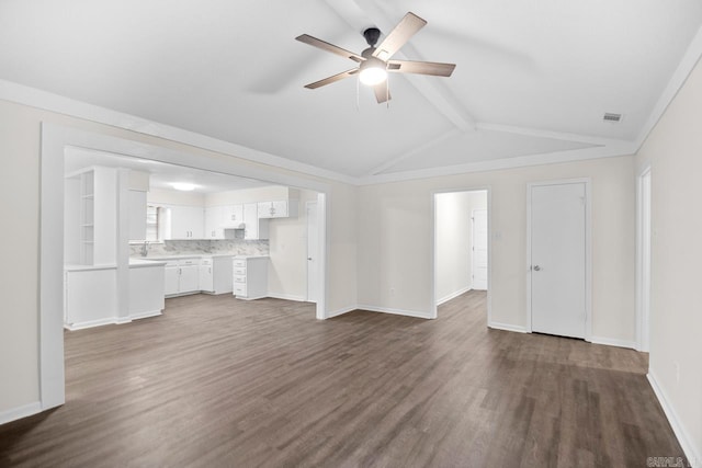 unfurnished living room featuring ceiling fan, vaulted ceiling with beams, and dark hardwood / wood-style floors