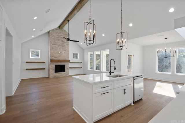 kitchen featuring stainless steel dishwasher, a kitchen island with sink, white cabinets, beamed ceiling, and sink