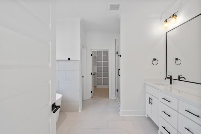 bathroom featuring a tub, tile patterned flooring, ornamental molding, and vanity