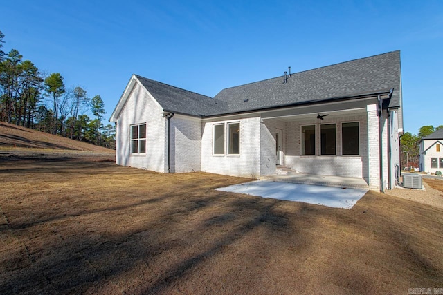 rear view of property featuring cooling unit, a patio area, ceiling fan, and a yard