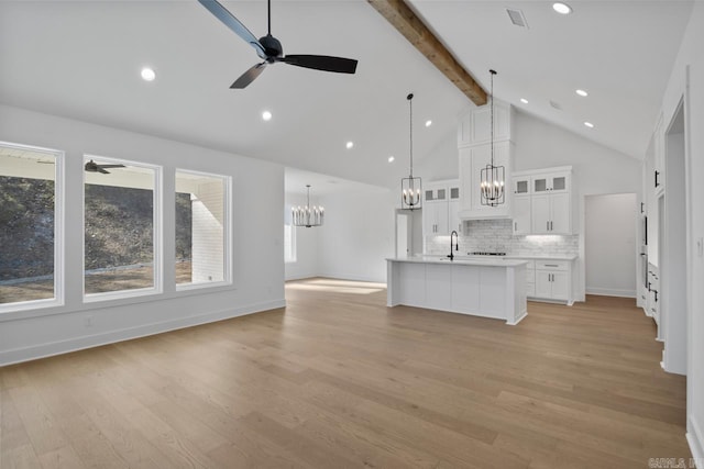 unfurnished living room with ceiling fan, light hardwood / wood-style floors, and beam ceiling