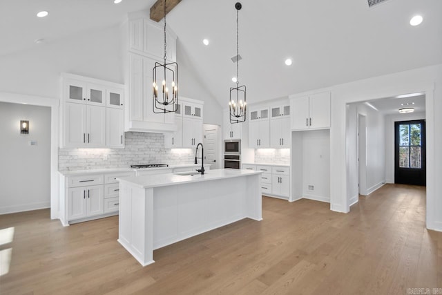 kitchen featuring sink, white cabinets, and a kitchen island with sink