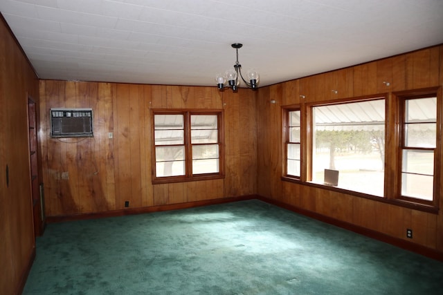 carpeted spare room featuring a wall mounted AC, wooden walls, and a chandelier