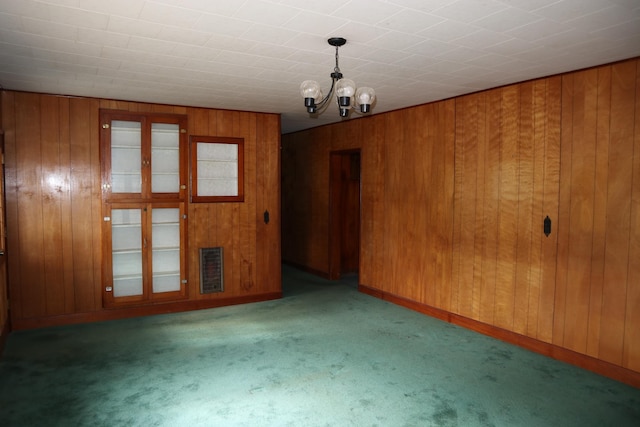 carpeted spare room with a notable chandelier