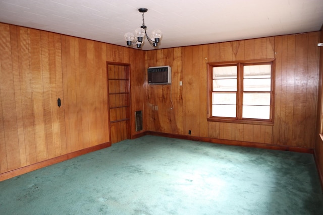 empty room with a wall unit AC, wood walls, and a notable chandelier