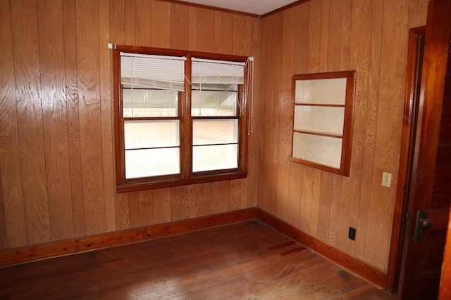 spare room featuring wooden walls and dark hardwood / wood-style floors