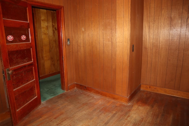 hallway with wood walls and hardwood / wood-style floors