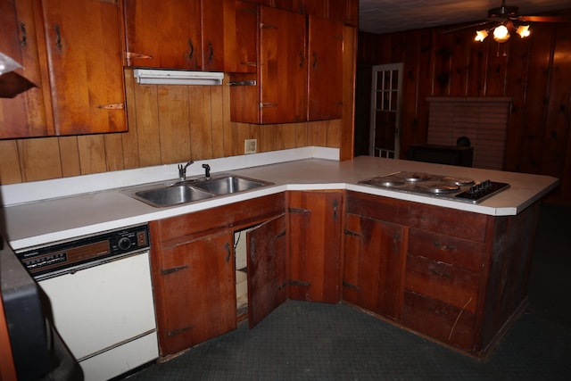 kitchen with gas stovetop, kitchen peninsula, ceiling fan, white dishwasher, and sink