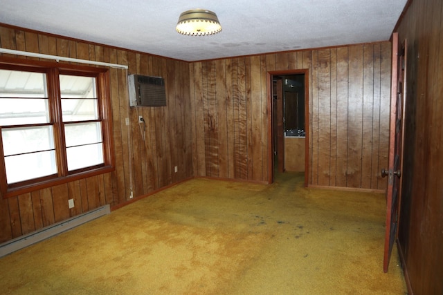 carpeted spare room with a wall mounted AC, wood walls, a baseboard radiator, and a textured ceiling