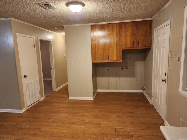 clothes washing area featuring washer hookup, a textured ceiling, hookup for an electric dryer, light wood-type flooring, and crown molding