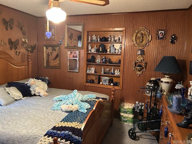 bedroom featuring carpet floors, a textured ceiling, and wood walls