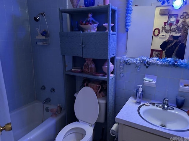 full bathroom with toilet, tile walls, backsplash, tiled shower / bath, and vanity