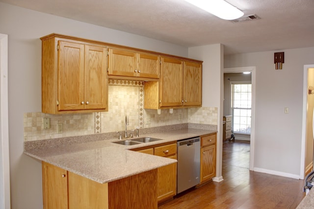 kitchen featuring sink, hardwood / wood-style floors, dishwasher, and tasteful backsplash