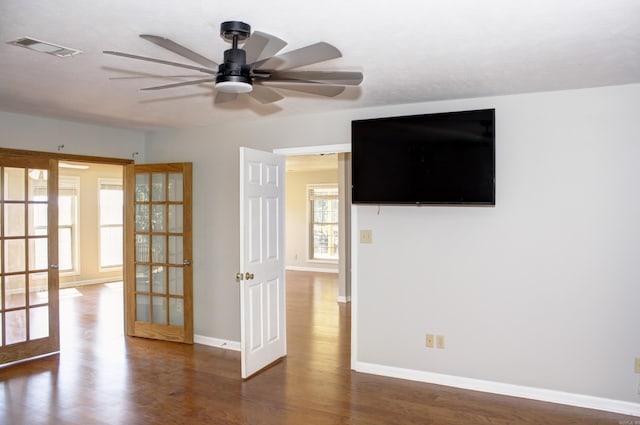 empty room featuring ceiling fan, dark hardwood / wood-style flooring, and french doors