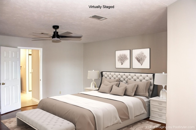 bedroom featuring hardwood / wood-style flooring, a textured ceiling, and ceiling fan