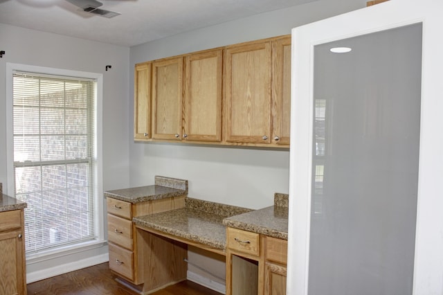 kitchen featuring dark hardwood / wood-style flooring, stone countertops, and light brown cabinets