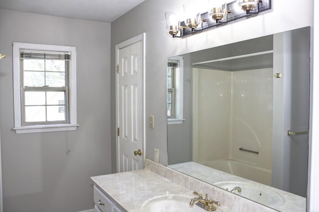 bathroom featuring washtub / shower combination and vanity