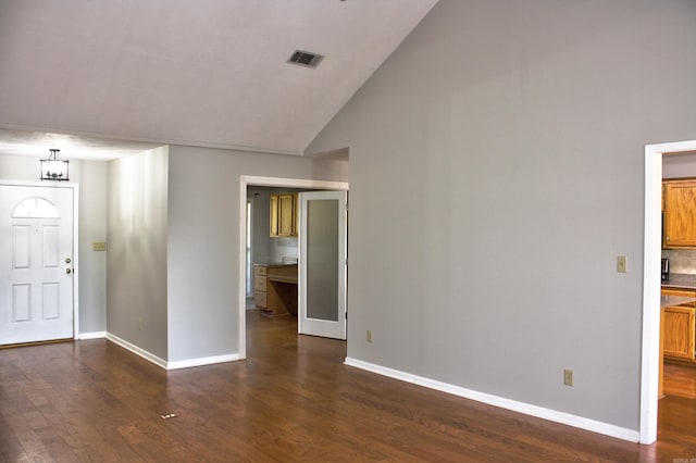 entrance foyer featuring an inviting chandelier, vaulted ceiling, and dark hardwood / wood-style floors