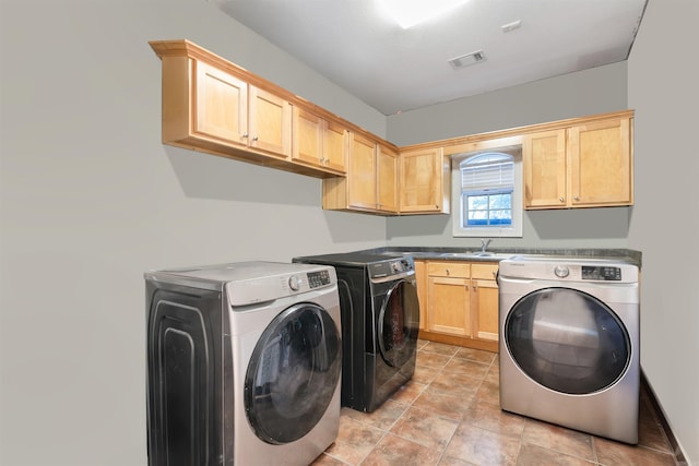 laundry room with washing machine and dryer, cabinets, and sink