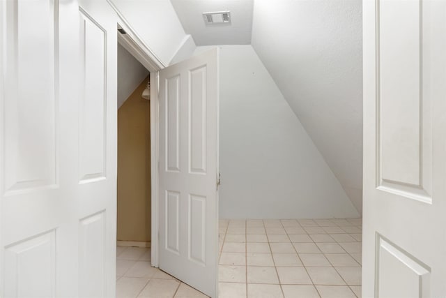 bonus room with light tile patterned flooring and lofted ceiling