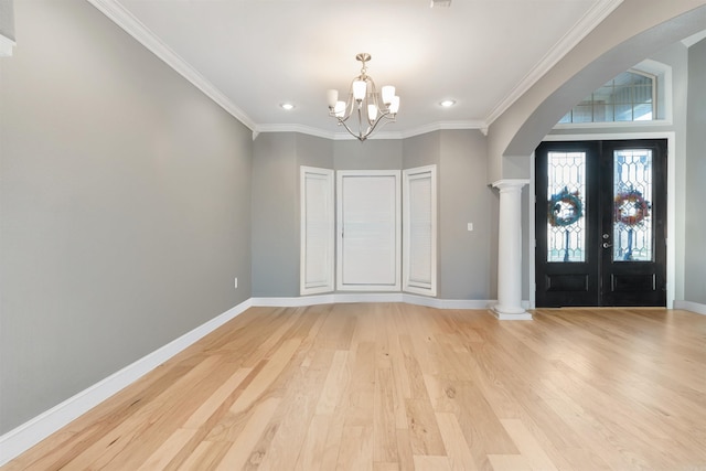 foyer entrance featuring ornamental molding, french doors, an inviting chandelier, and light wood-type flooring