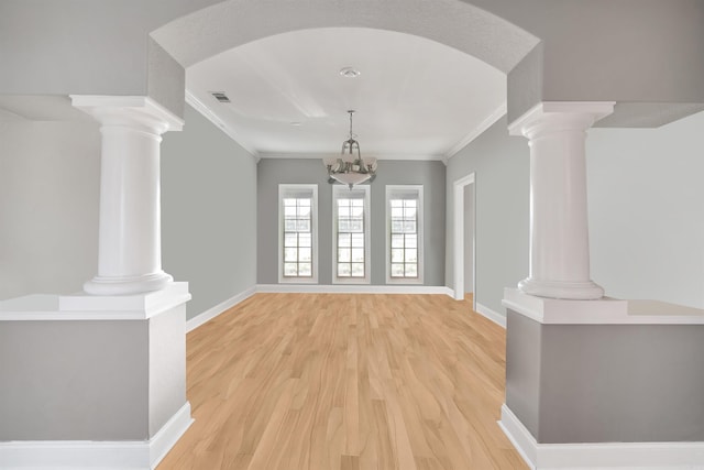 unfurnished living room featuring ornamental molding, light hardwood / wood-style flooring, and a chandelier