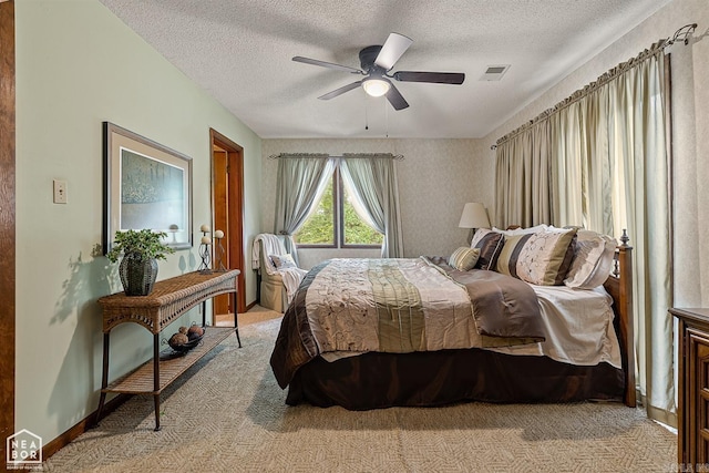 carpeted bedroom featuring a textured ceiling and ceiling fan