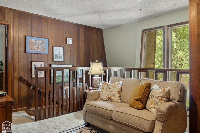 living room with a textured ceiling and wood walls