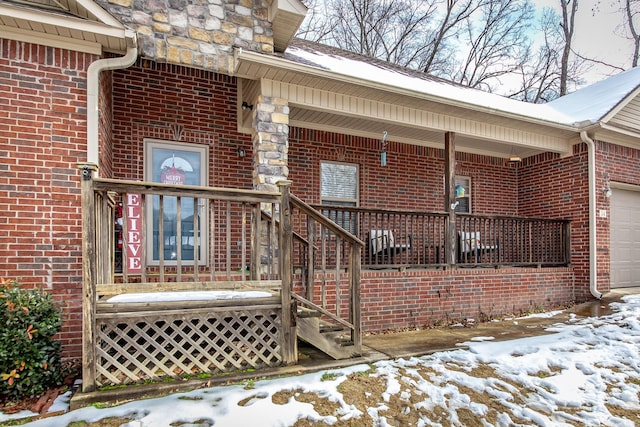 snow covered property entrance featuring covered porch