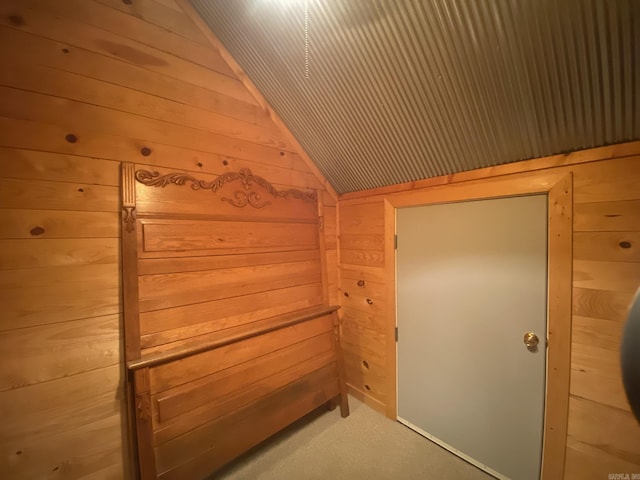 bonus room featuring lofted ceiling and wood walls