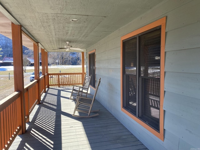 wooden terrace with covered porch and ceiling fan